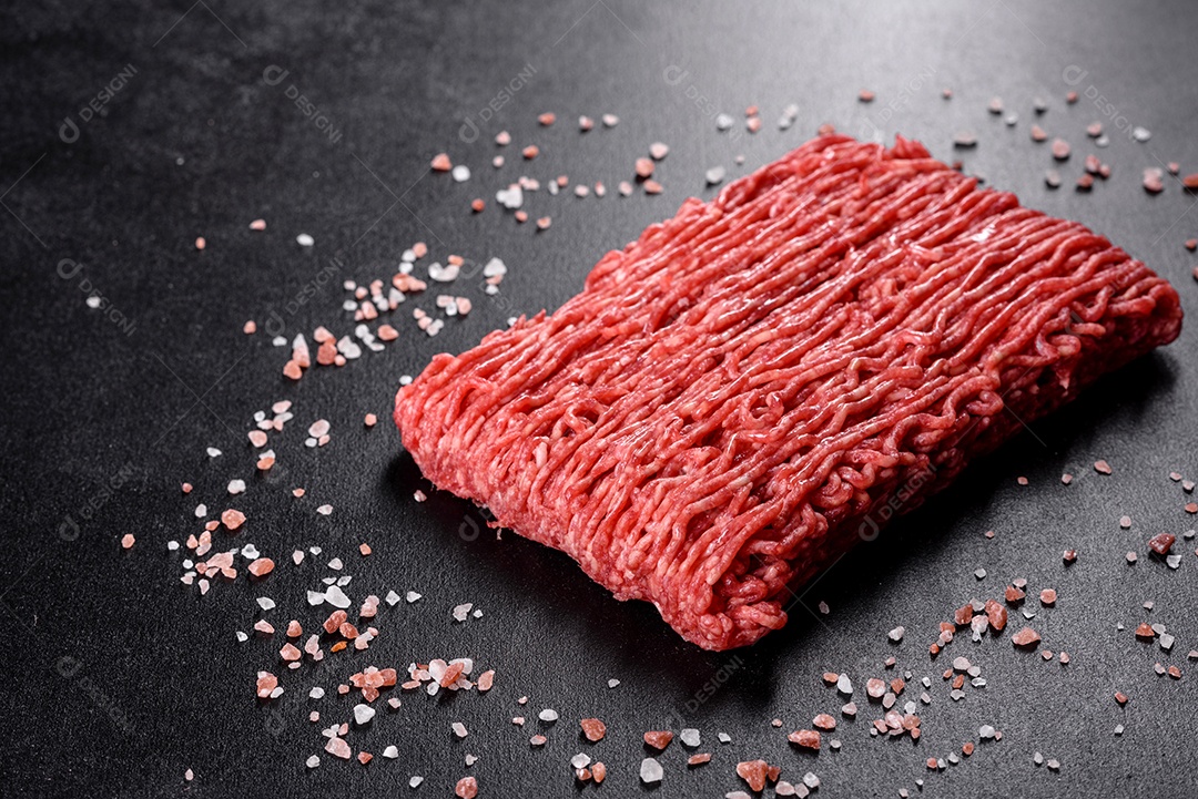 Carne crua fresca picada em um fundo escuro. Preparação para cozinhar costeletas