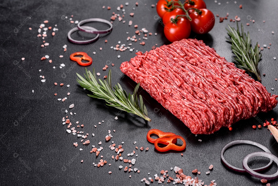 Carne crua fresca picada em um fundo escuro. Preparação para cozinhar costeletas