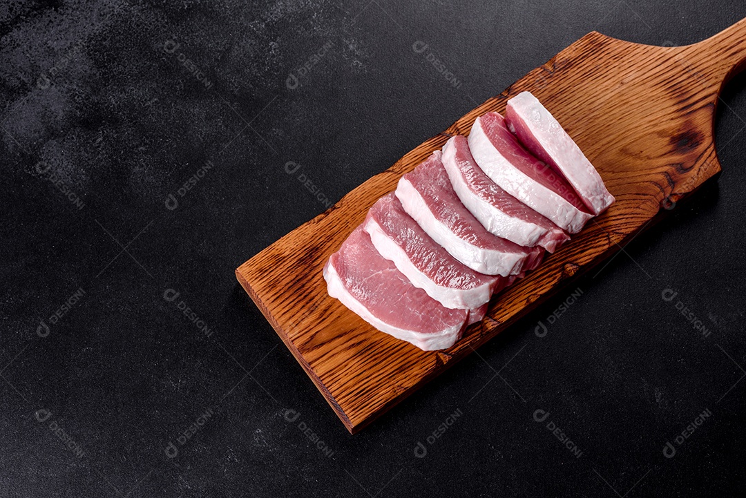 Um pedaço fresco de escalope de porco cru cortado em várias partes. Preparando Carne para Assar