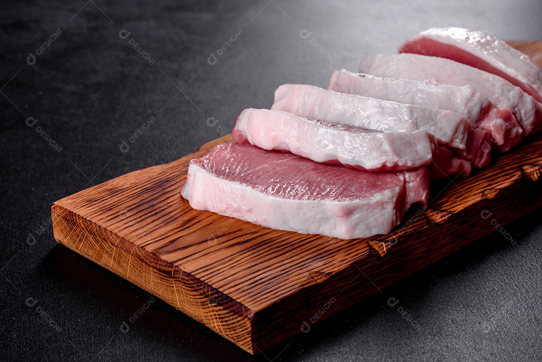 Um pedaço fresco de escalope de porco cru cortado em várias partes. Preparando Carne para Assar