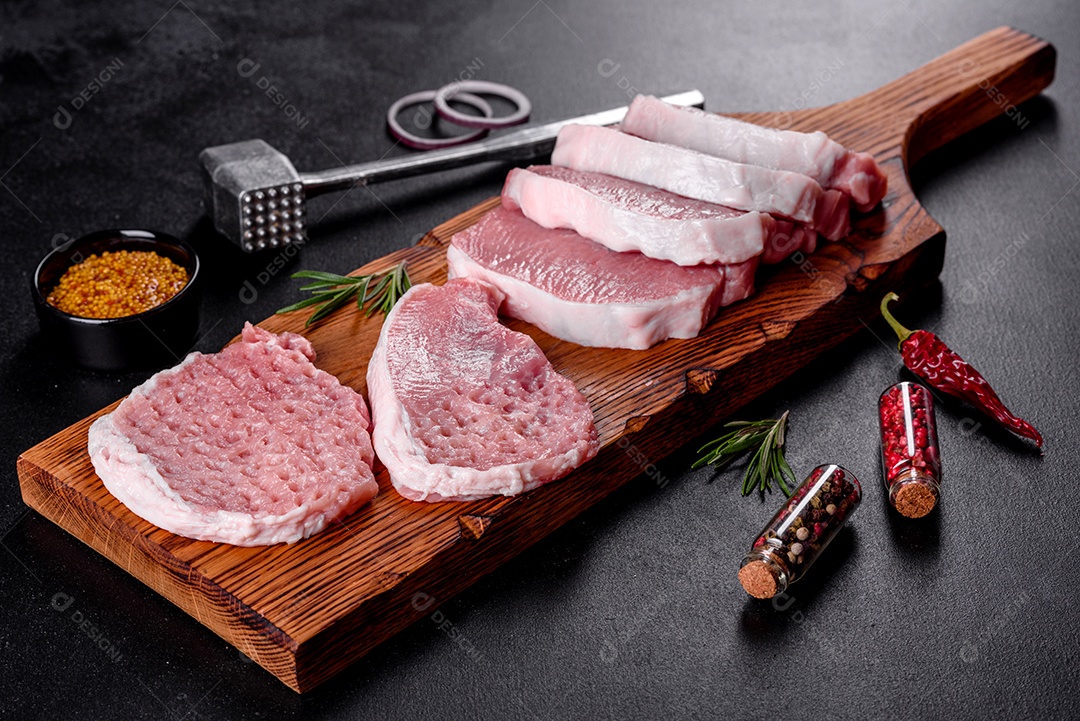 Um pedaço fresco de escalope de porco cru cortado em várias partes. Preparando Carne para Assar