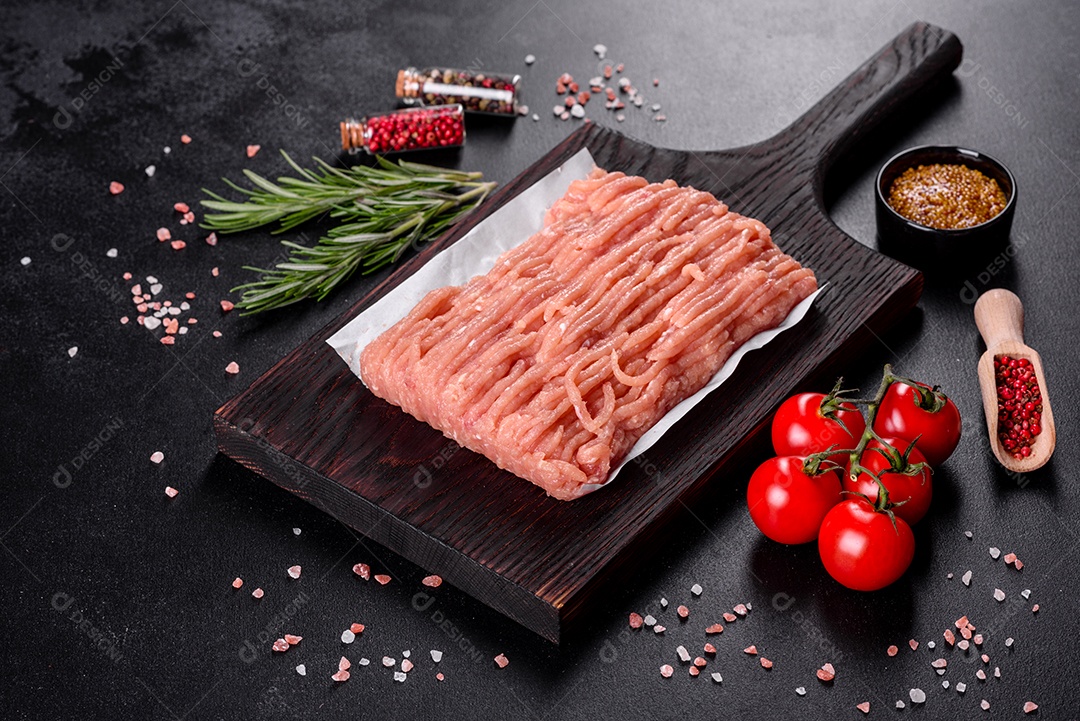 Frango cru fresco picado em uma tábua de madeira escura. Preparação para preparação de costeletas