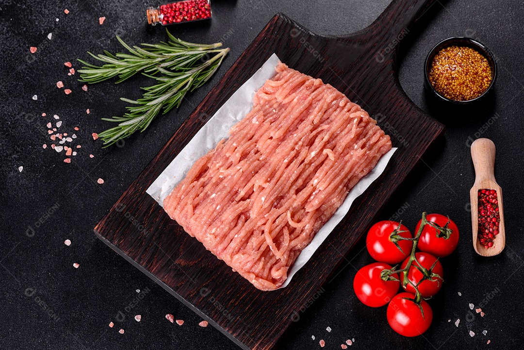 Frango cru fresco picado em uma tábua de madeira escura. Preparação para preparação de costeletas