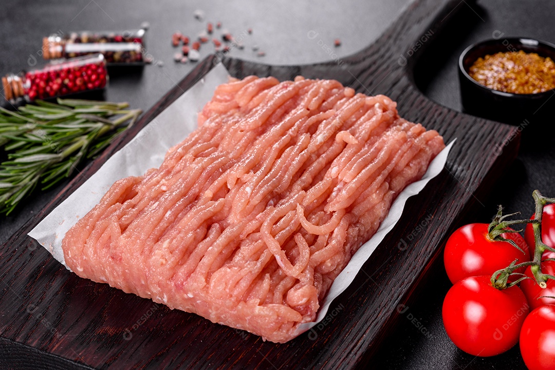 Frango cru fresco picado em uma tábua de madeira escura. Preparação para preparação de costeletas