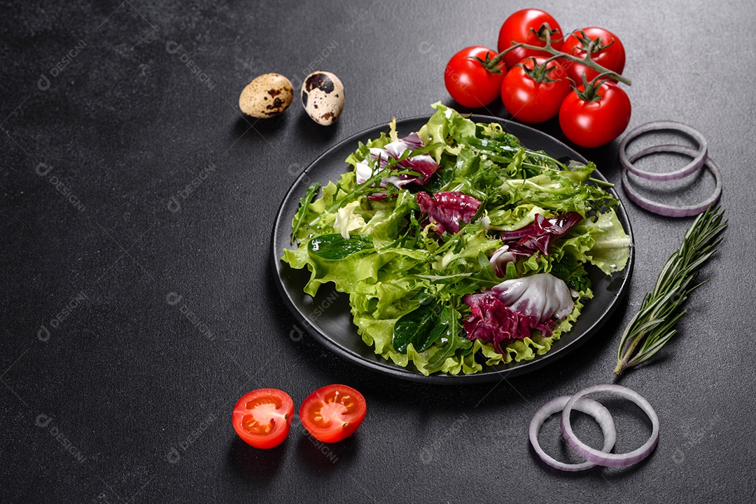 Salada vegetariana deliciosa e fresca de legumes picados em um prato sobre um fundo escuro de concreto