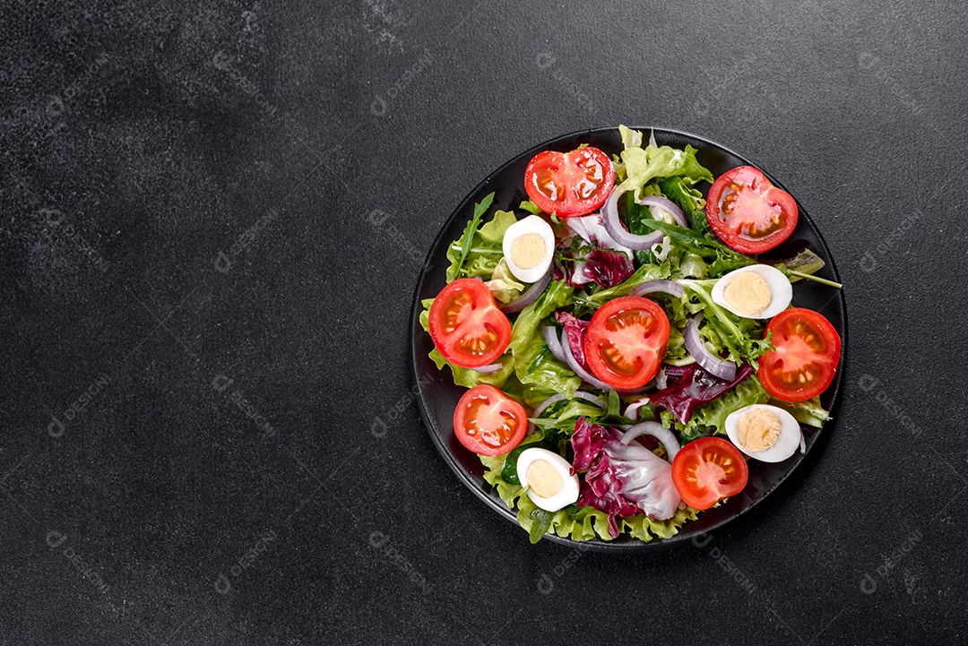 Salada vegetariana deliciosa e fresca de legumes picados em um prato sobre um fundo escuro de concreto