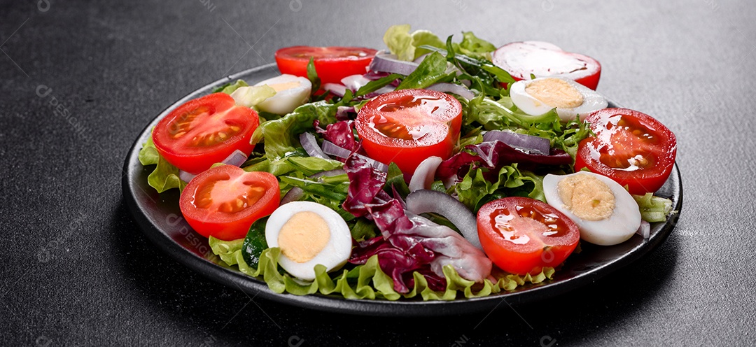 Salada vegetariana deliciosa e fresca de legumes picados em um prato sobre um fundo escuro de concreto