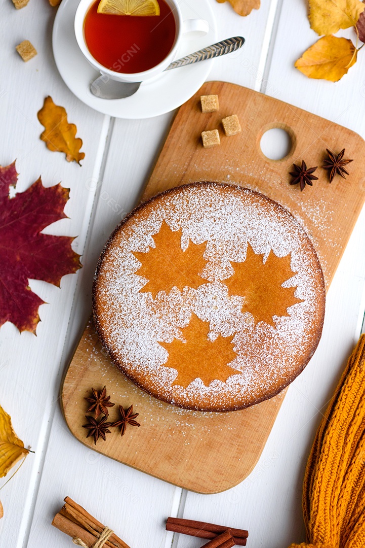 Lindo bolo de abóbora doce fresco com um padrão de folha de bordo sobre um fundo branco de madeira com uma composição de folhas secas de outono