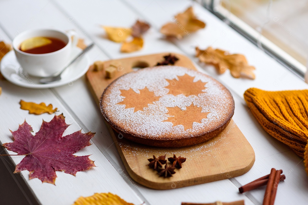 Lindo bolo de abóbora doce fresco com um padrão de folha de bordo sobre um fundo branco de madeira com uma composição de folhas secas de outono