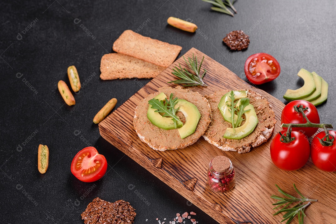 Delicioso sanduíche fresco com peixe vermelho, manteiga, pão e abacate em uma mesa de concreto escuro