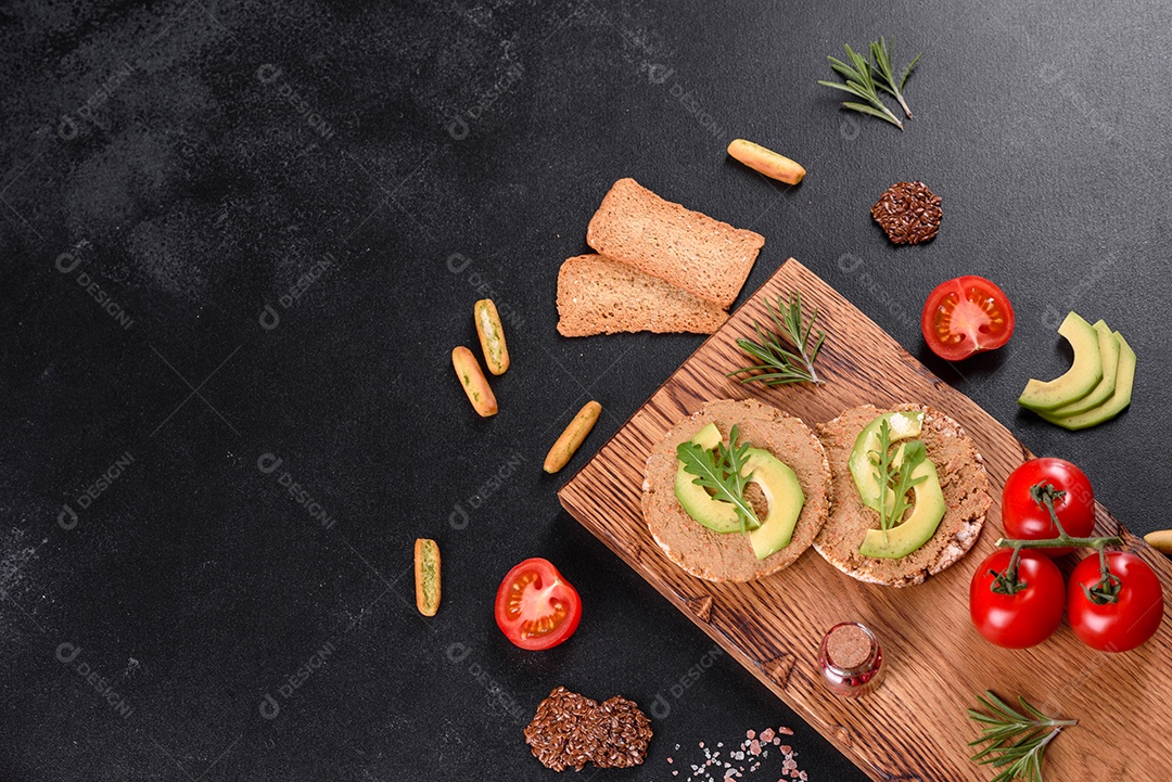 Delicioso sanduíche fresco com peixe vermelho, manteiga, pão e abacate em uma mesa de concreto escuro