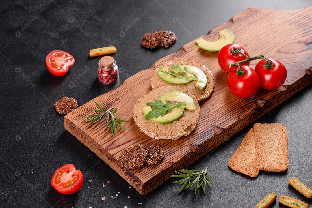 Delicioso sanduíche fresco com peixe vermelho, manteiga, pão e abacate em uma mesa de concreto escuro