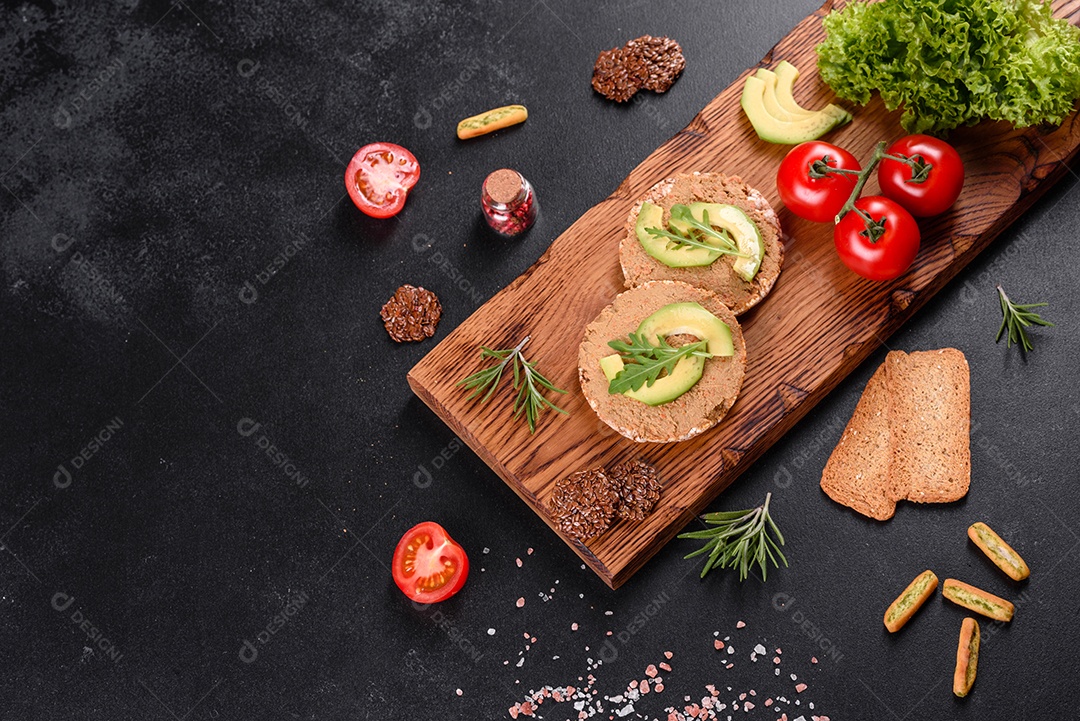 Delicioso sanduíche fresco com peixe vermelho, manteiga, pão e abacate em uma mesa de concreto escuro