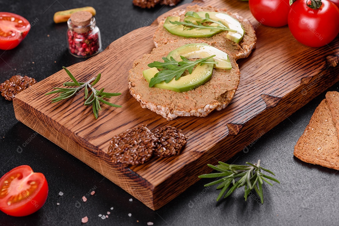 Delicioso sanduíche fresco com peixe vermelho, manteiga, pão e abacate em uma mesa de concreto escuro