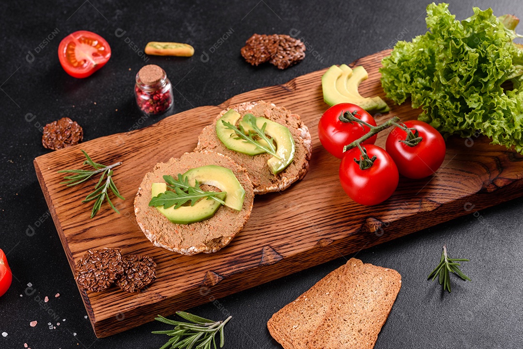 Delicioso sanduíche fresco com peixe vermelho, manteiga, pão e abacate em uma mesa de concreto escuro