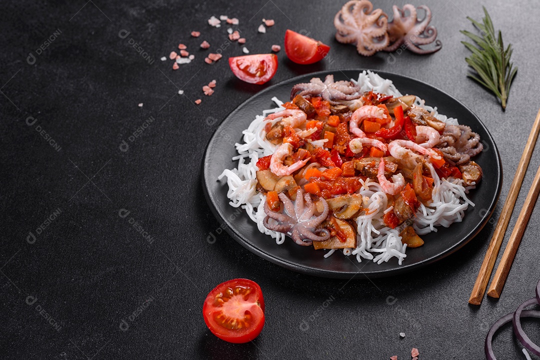 Macarrão de arroz saboroso com tomate, pimenta vermelha, cogumelos e frutos do mar em um fundo escuro de concreto