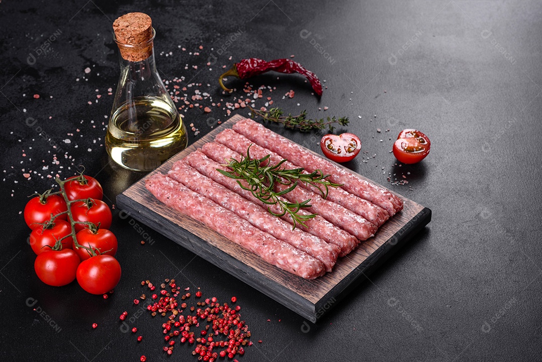 Salsichas de porco cruas frescas com especiarias numa tábua de madeira sobre uma mesa de concreto escuro