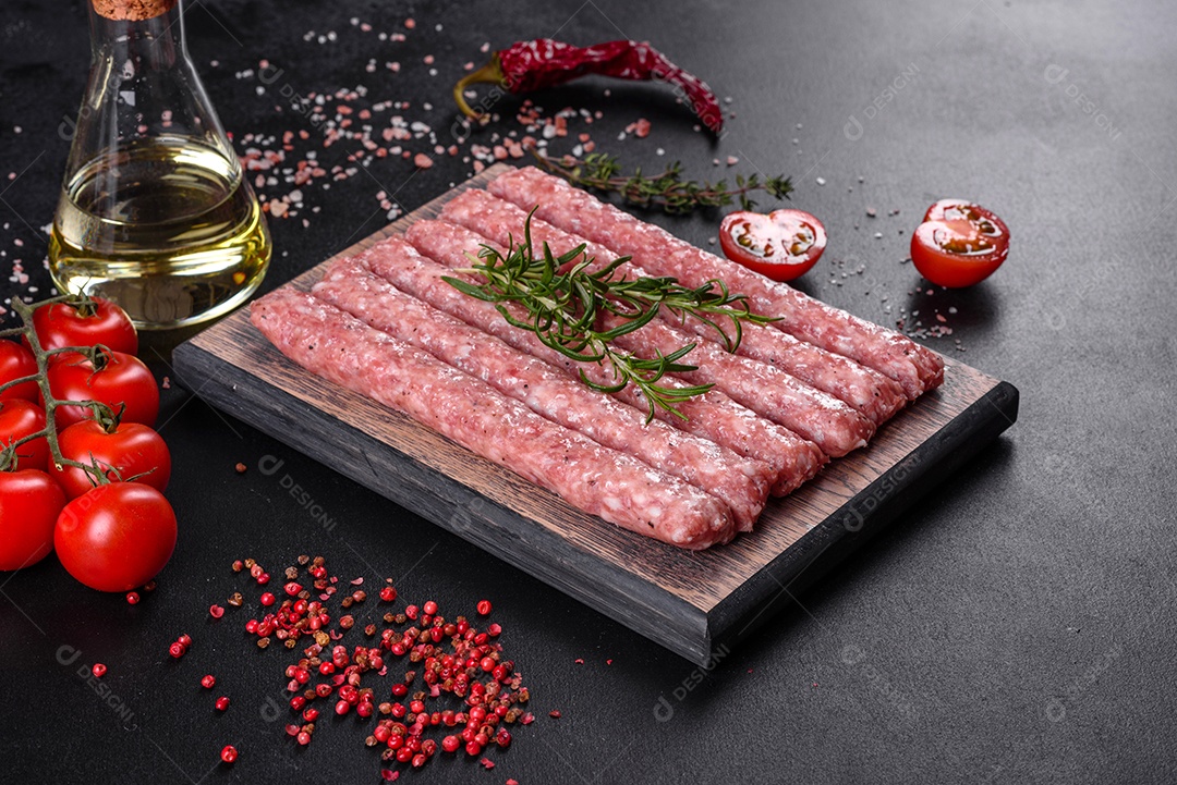 Salsichas de porco cruas frescas com especiarias numa tábua de madeira sobre uma mesa de concreto escuro