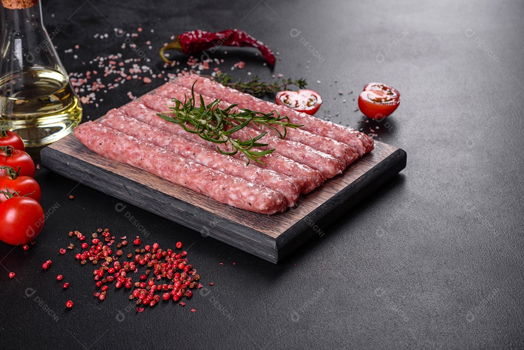 Salsichas de porco cruas frescas com especiarias numa tábua de madeira sobre uma mesa de concreto escuro