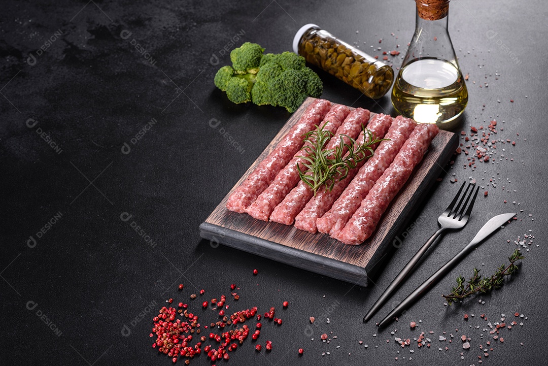 Salsichas de porco cruas frescas com especiarias numa tábua de madeira sobre uma mesa de concreto escuro