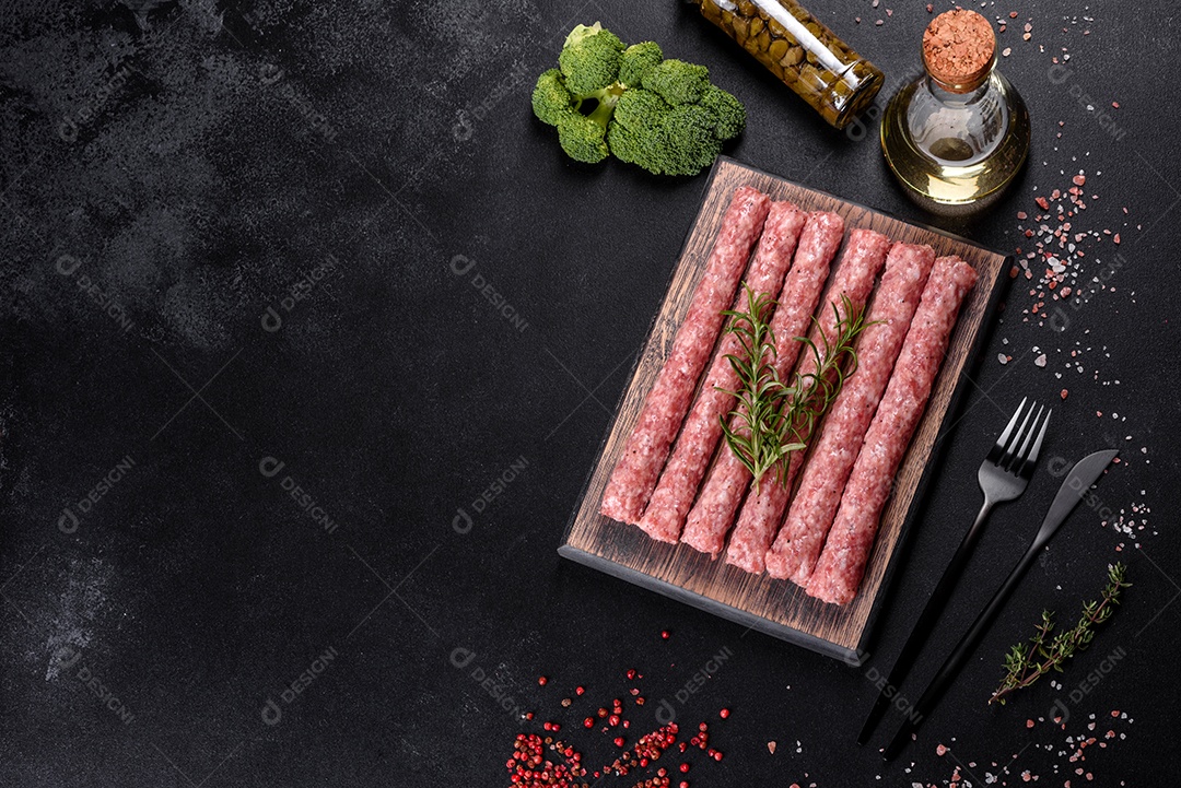 Salsichas de porco cruas frescas com especiarias numa tábua de madeira sobre uma mesa de concreto escuro