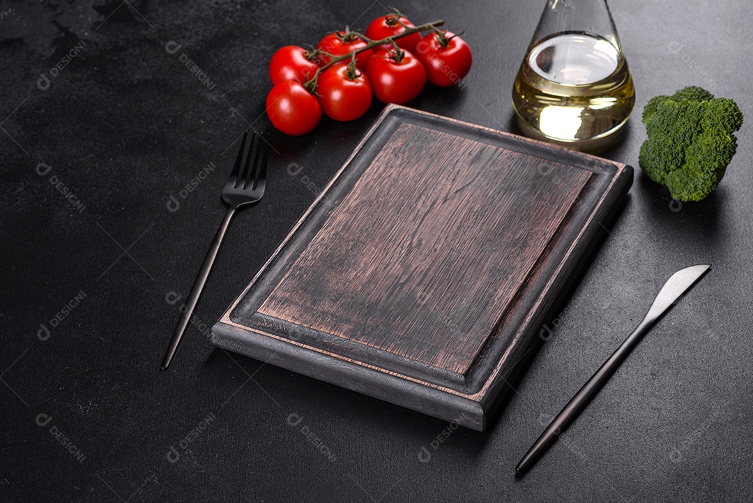 Talheres pretos sobre uma mesa escura de concreto. Preparação da mesa de jantar