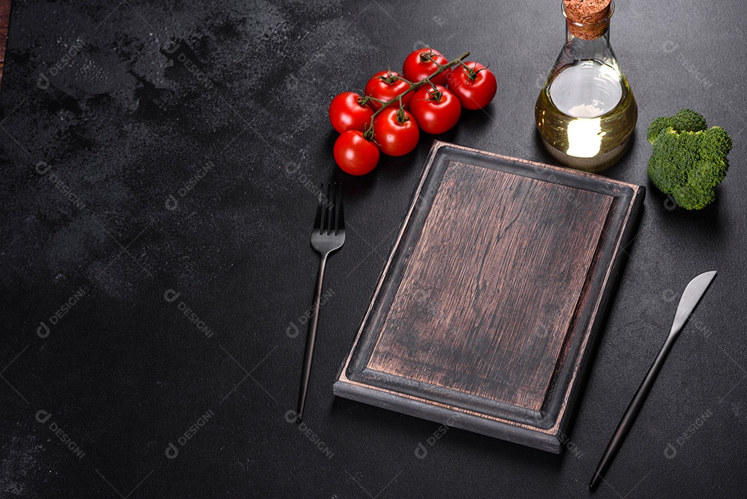 Talheres pretos sobre uma mesa escura de concreto. Preparação da mesa de jantar