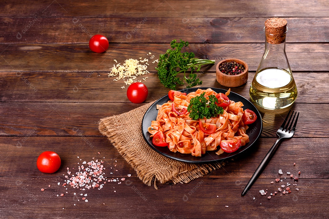 Deliciosa pasta fresca com molho de tomate com especiarias e ervas sobre fundo escuro. Cozinha mediterrâne