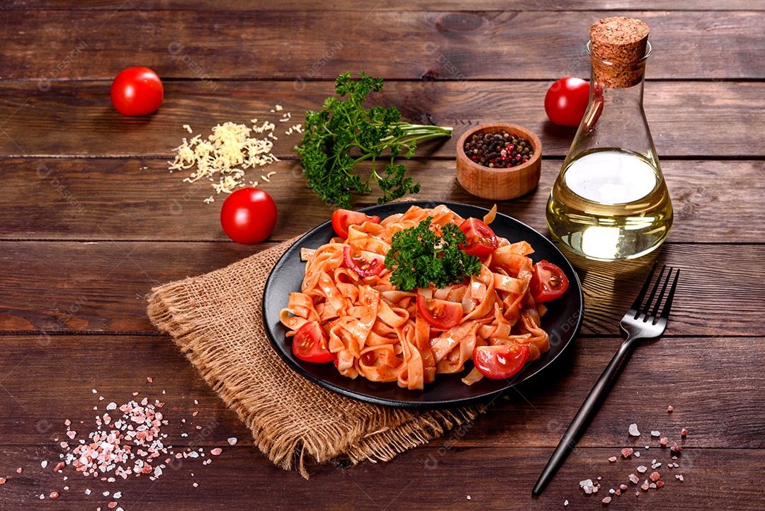 Deliciosa pasta fresca com molho de tomate com especiarias e ervas sobre fundo escuro. Cozinha mediterrânea