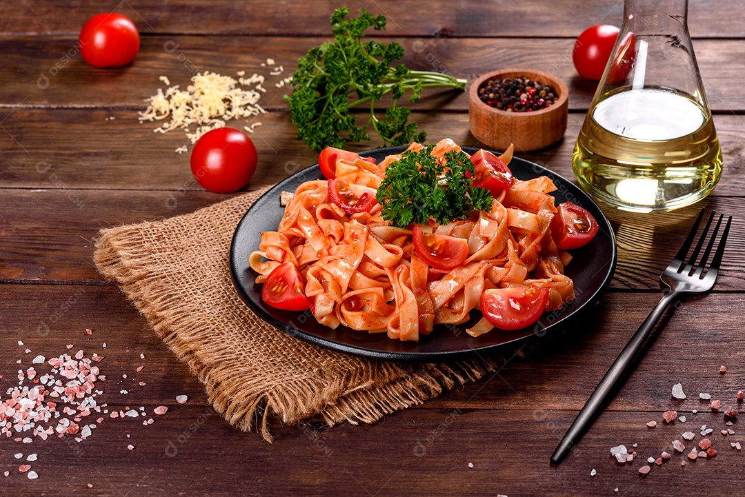 Deliciosa pasta fresca com molho de tomate com especiarias e ervas sobre fundo escuro. Cozinha mediterrânea