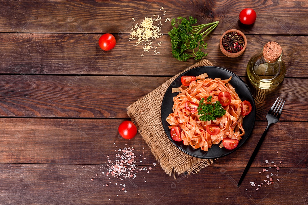 Deliciosa pasta fresca com molho de tomate com especiarias e ervas sobre fundo escuro. Cozinha mediterrânea
