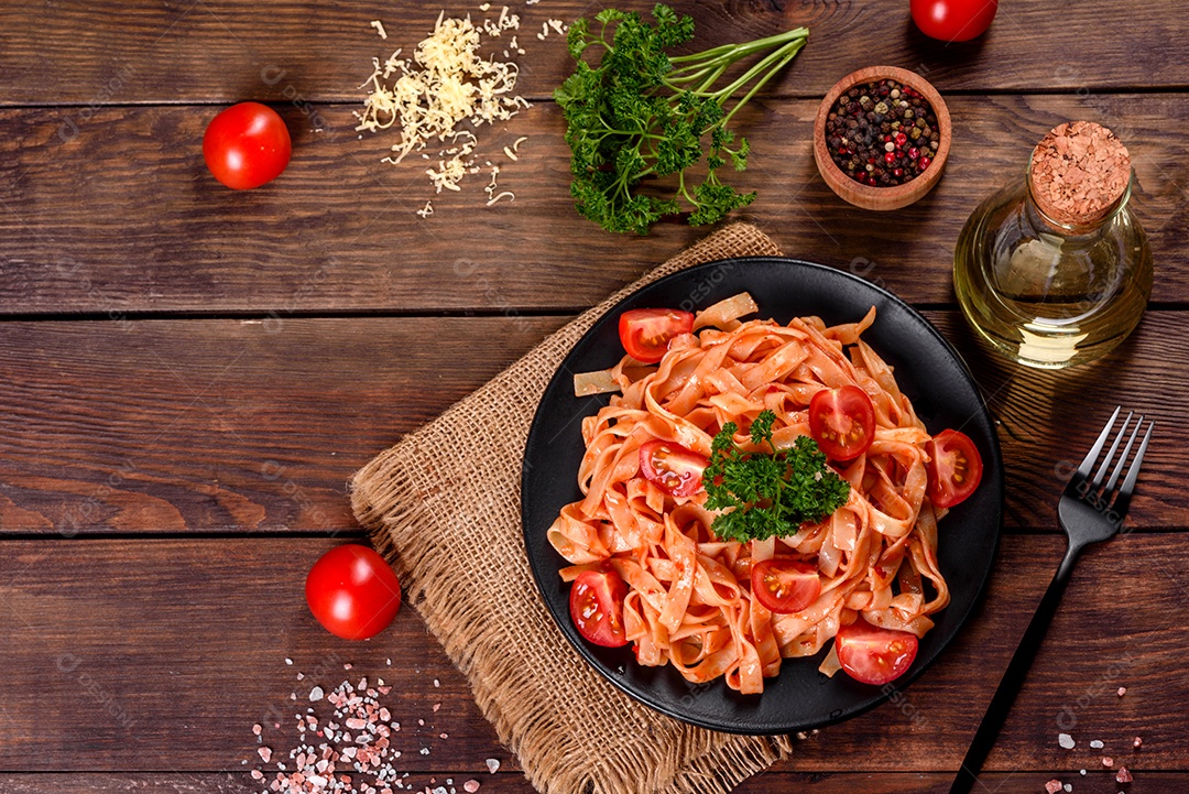 Deliciosa pasta fresca com molho de tomate com especiarias e ervas sobre fundo escuro. Cozinha mediterrânea