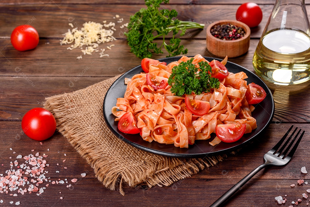 Deliciosa pasta fresca com molho de tomate com especiarias e ervas sobre fundo escuro. Cozinha mediterrânea