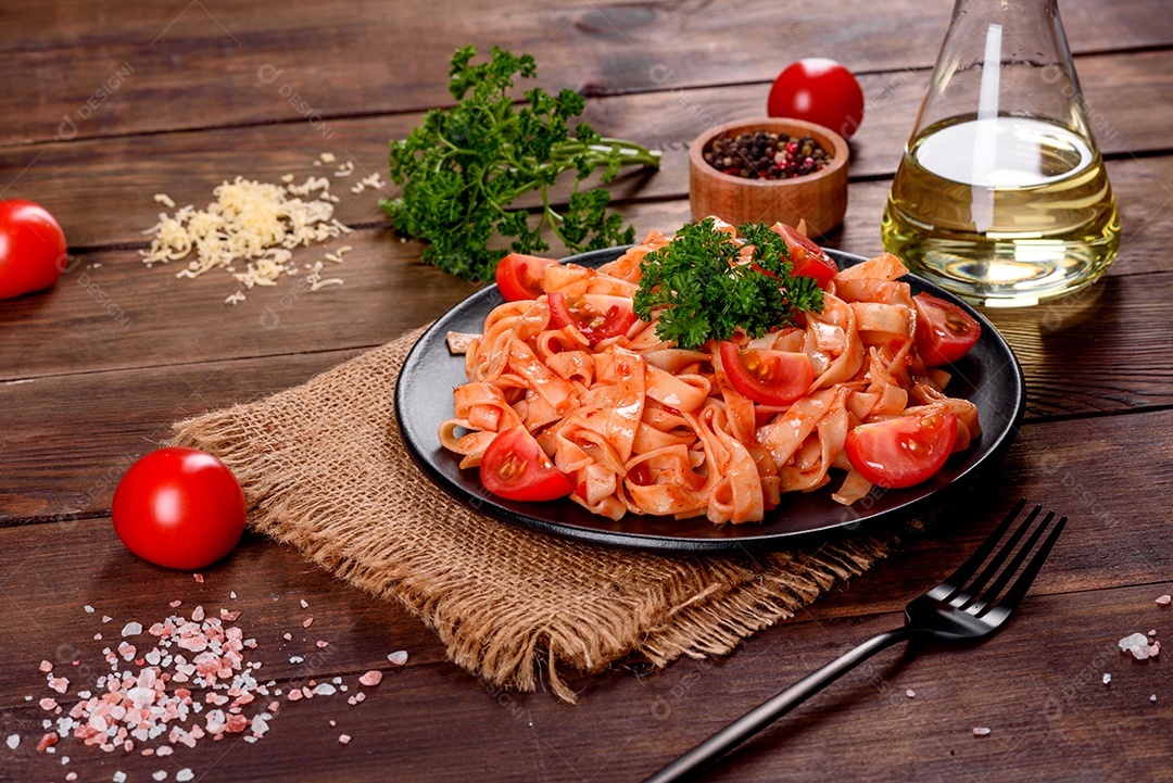 Deliciosa pasta fresca com molho de tomate com especiarias e ervas sobre fundo escuro. Cozinha mediterrânea