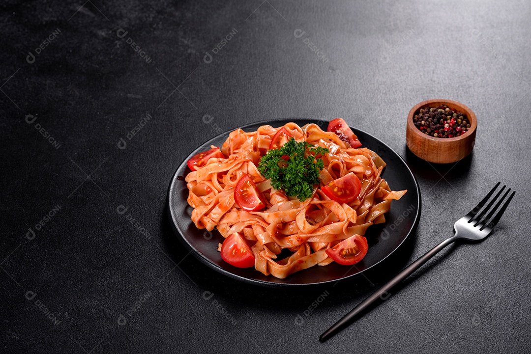 Deliciosa pasta fresca com molho de tomate com especiarias e ervas sobre fundo escuro. Cozinha mediterrânea