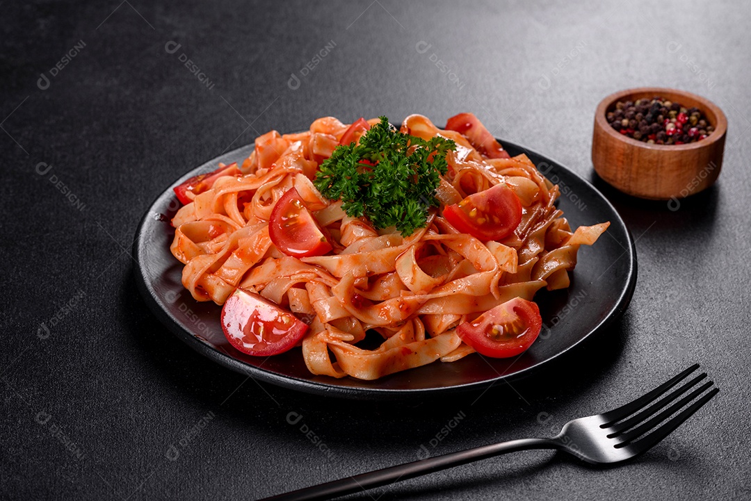 Deliciosa pasta fresca com molho de tomate com especiarias e ervas sobre fundo escuro. Cozinha mediterrânea