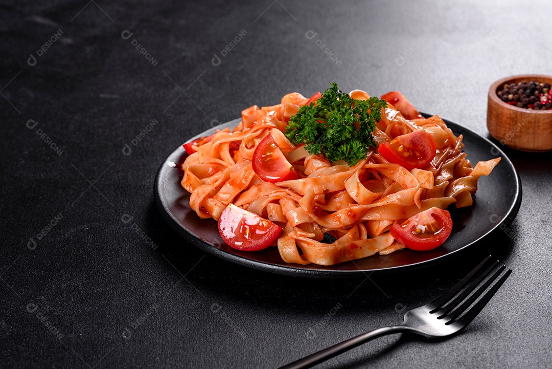 Deliciosa pasta fresca com molho de tomate com especiarias e ervas sobre fundo escuro. Cozinha mediterrânea