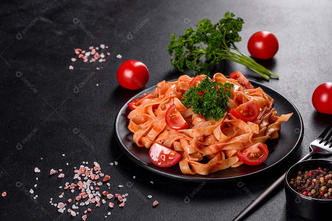 Deliciosa pasta fresca com molho de tomate com especiarias e ervas sobre fundo escuro. Cozinha mediterrânea