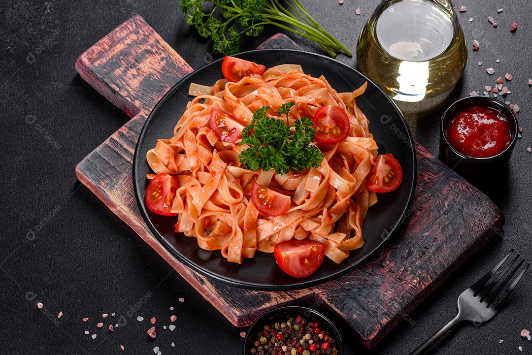 Deliciosa pasta fresca com molho de tomate com especiarias e ervas sobre fundo escuro. Cozinha mediterrânea