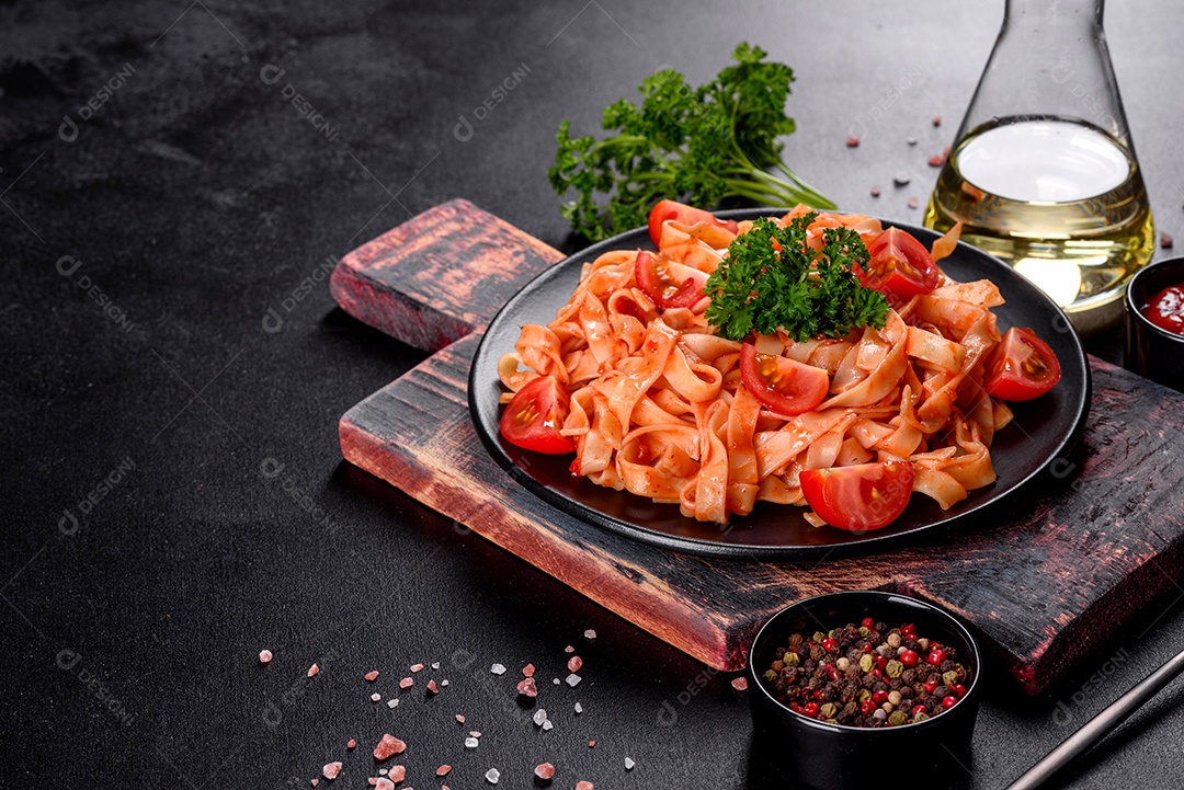Deliciosa pasta fresca com molho de tomate com especiarias e ervas sobre fundo escuro. Cozinha mediterrânea