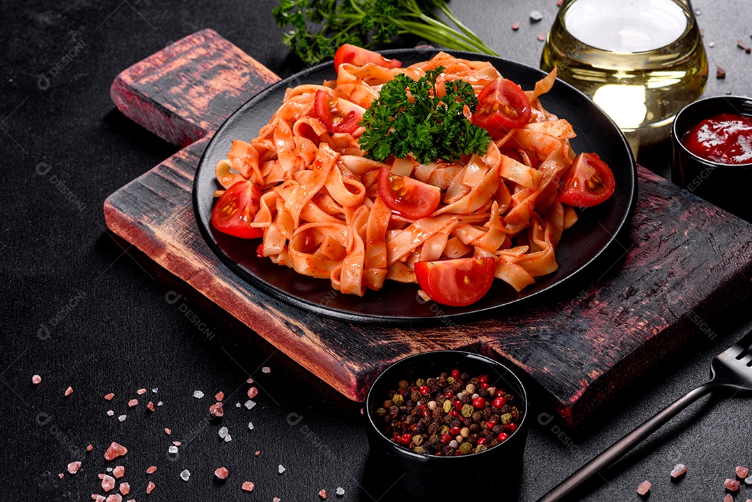 Deliciosa pasta fresca com molho de tomate com especiarias e ervas sobre fundo escuro. Cozinha mediterrânea