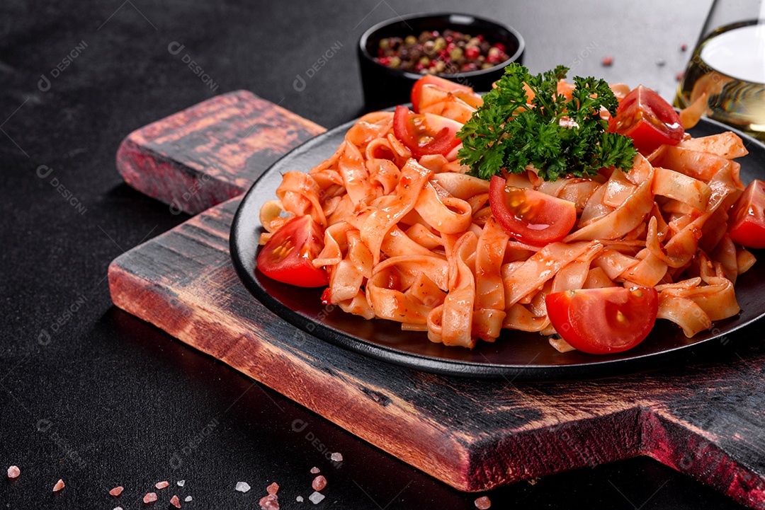 Deliciosa pasta fresca com molho de tomate com especiarias e ervas sobre fundo escuro. Cozinha mediterrânea
