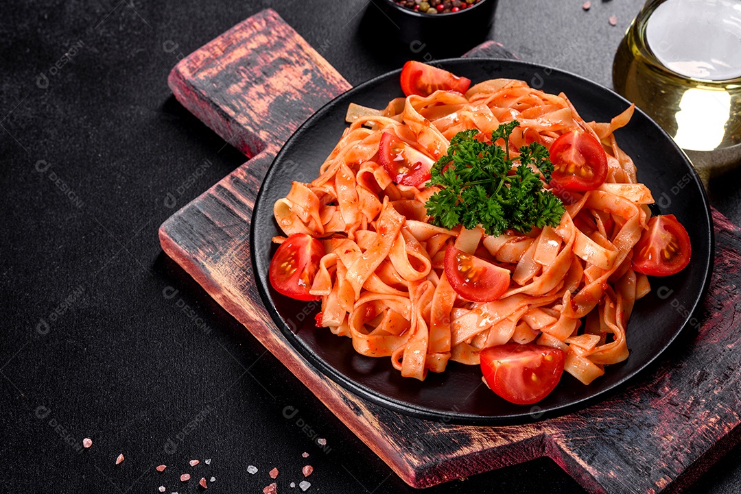 Deliciosa pasta fresca com molho de tomate com especiarias e ervas sobre fundo escuro. Cozinha mediterrânea