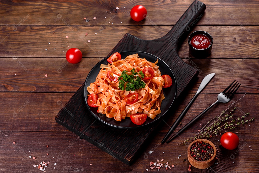Deliciosa pasta fresca com molho de tomate com especiarias e ervas sobre fundo escuro. Cozinha mediterrânea
