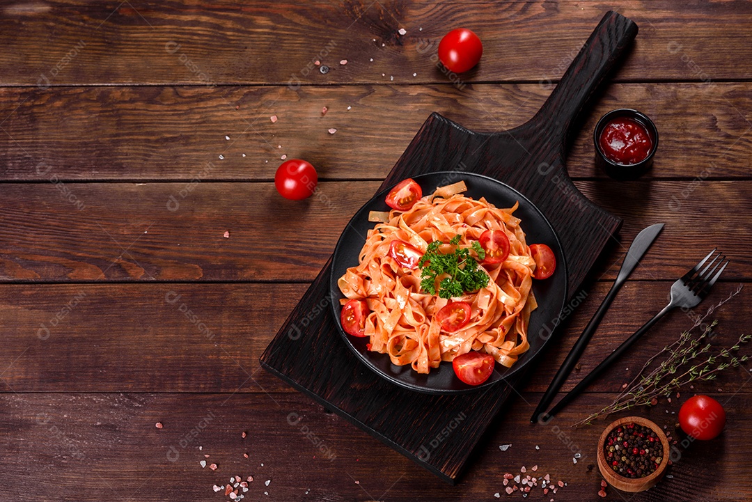 Deliciosa pasta fresca com molho de tomate com especiarias e ervas sobre fundo escuro. Cozinha mediterrânea