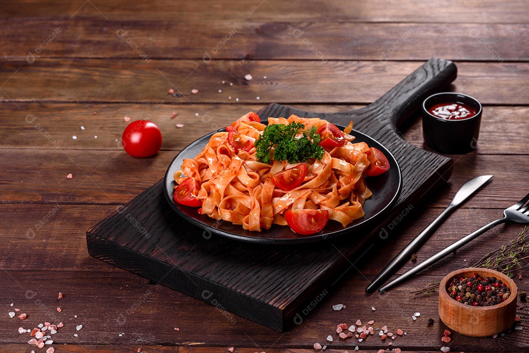 Deliciosa pasta fresca com molho de tomate com especiarias e ervas sobre fundo escuro. Cozinha mediterrânea