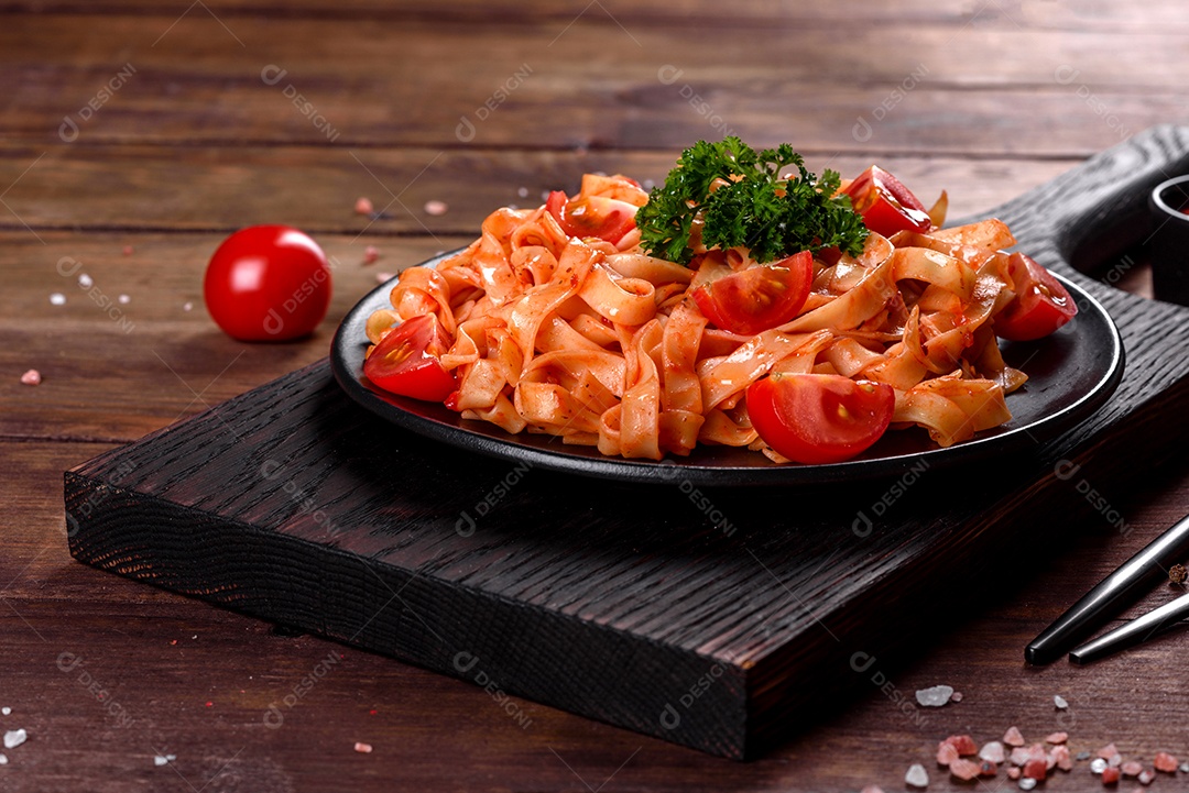 Deliciosa pasta fresca com molho de tomate com especiarias e ervas sobre fundo escuro. Cozinha mediterrânea