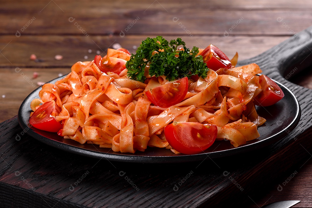 Deliciosa pasta fresca com molho de tomate com especiarias e ervas sobre fundo escuro. Cozinha mediterrânea