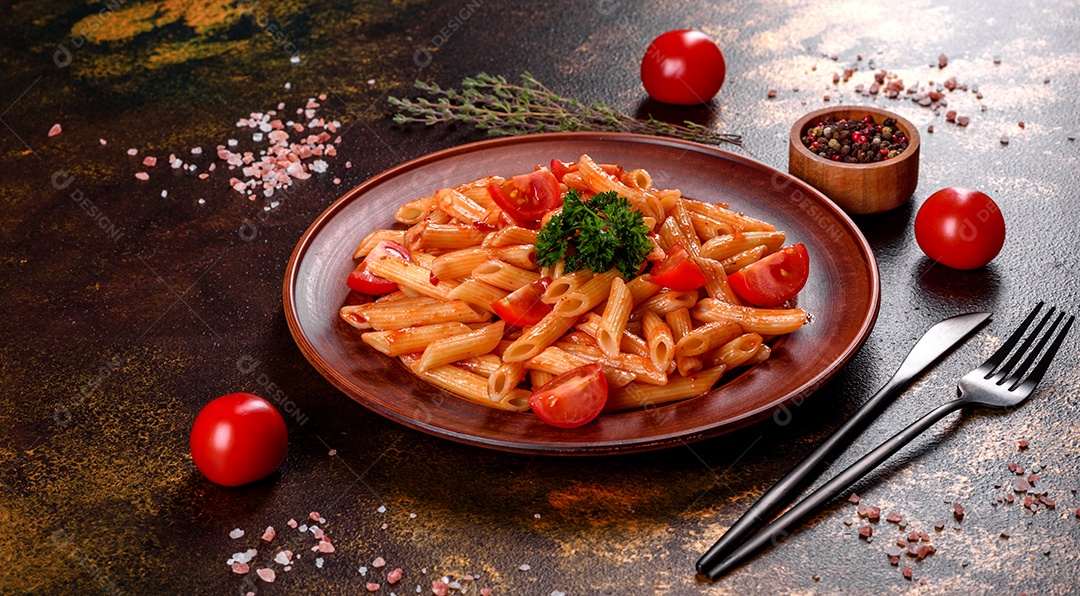 Deliciosa pasta fresca com molho de tomate com especiarias e ervas sobre fundo escuro. Cozinha mediterrânea