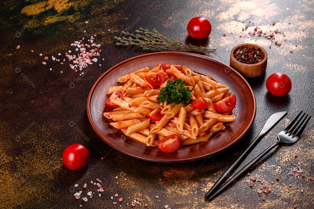 Deliciosa pasta fresca com molho de tomate com especiarias e ervas sobre fundo escuro. Cozinha mediterrânea